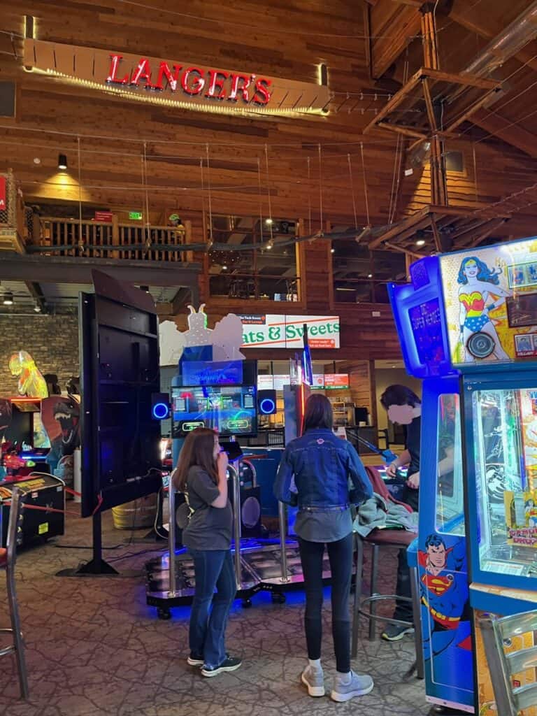 Our girls inside the large arcade section of Langer's entertainment with the high ropes course overhead.