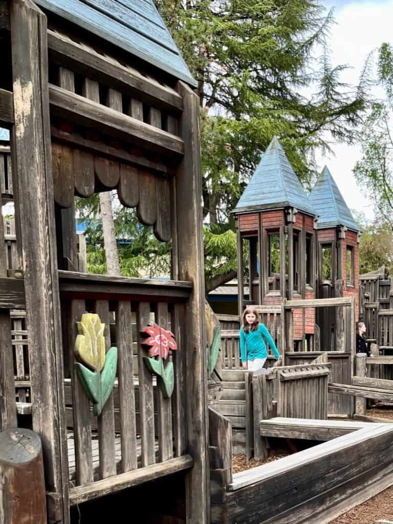 Girl climbing through the wooden play structure in McMinnville's City Park