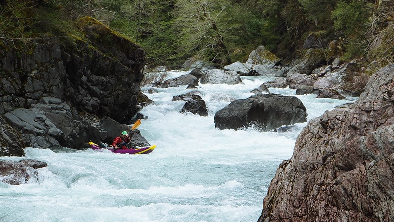 A kayaker navigates rapids along the Smith River at Smith River National Recreation Area. Smith River NRA is one of the best national parks to visit in November and December.