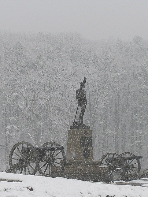 Snow falls amid the monuments and cannons of Gettysburg National Military Park. Gettysburg National Military Park is one of the best national parks to visit in November and December.