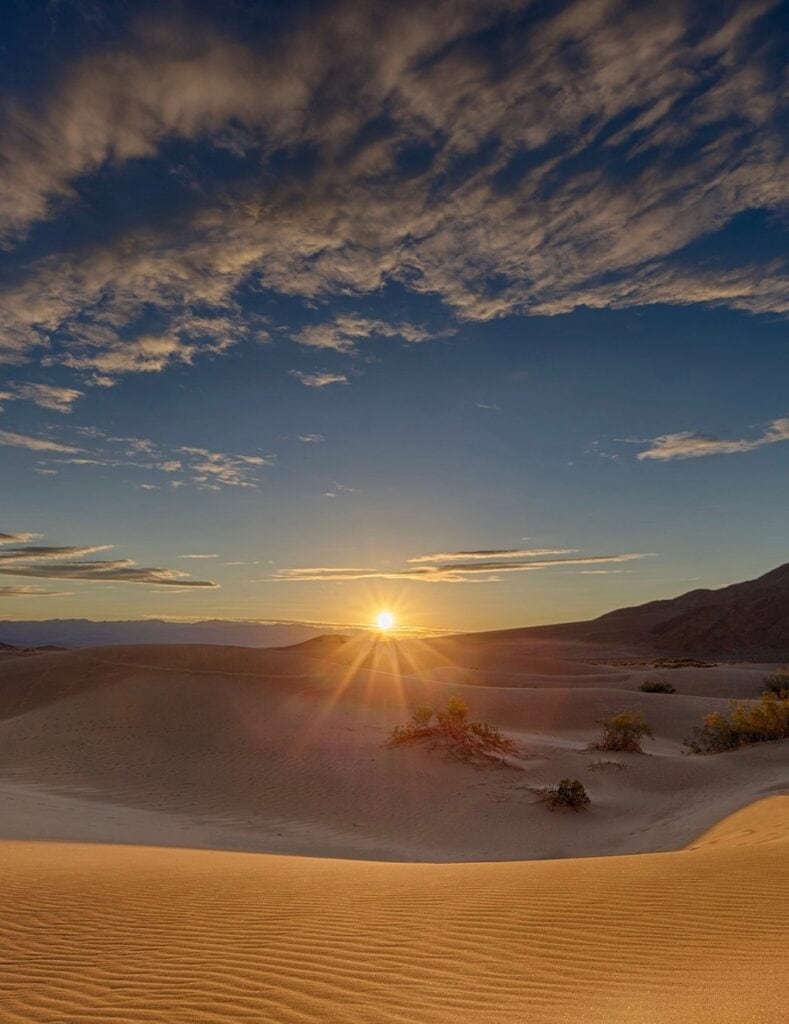 The sun rises over the desert wilderness of Death Valley National Park. Death Valley National Park is one of the best national parks to visit in November and December.