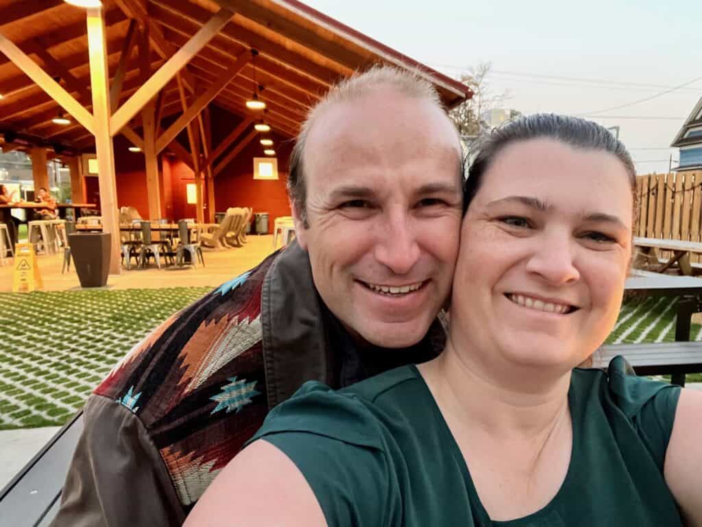 Brian and Jenn with The Den dining pavilion in the background. Best restaurants in Silverton Oregon.