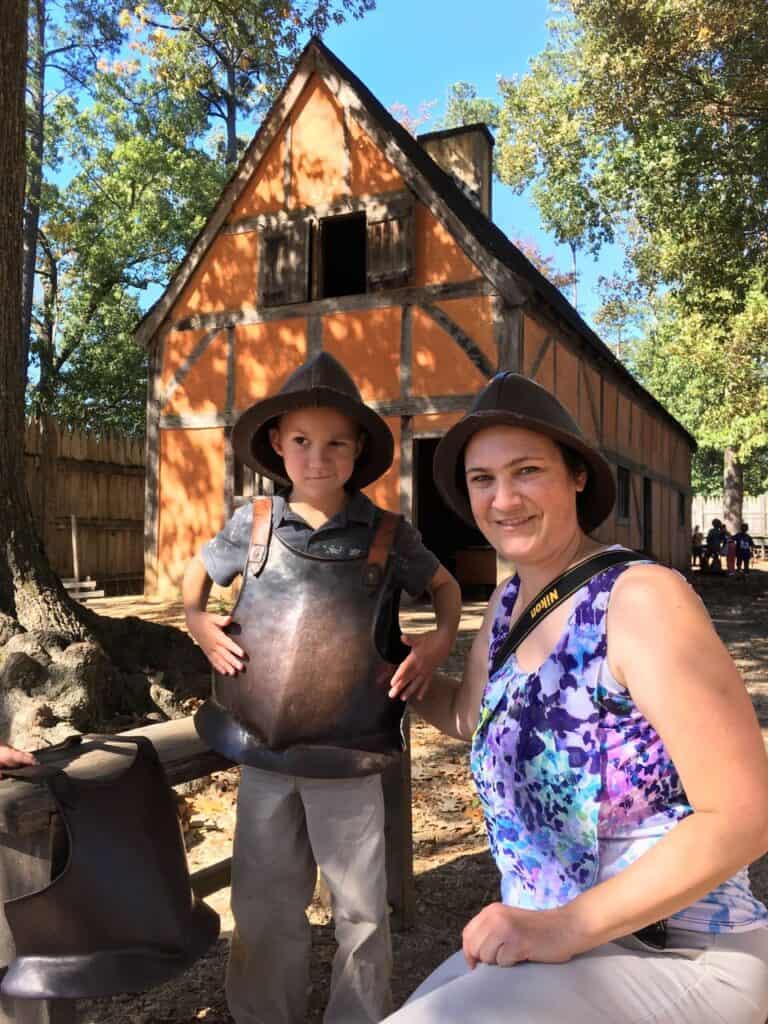 Our son smirks with disapproval as he poses in colonial armor at Colonial National Historical Park. Colonial National Historical Park is one of the best national parks to visit in November and December.