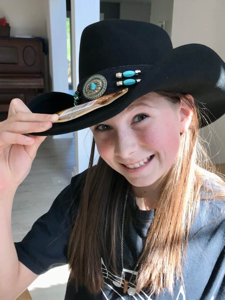 Our daughter in her black cowgirl hat with turquoise accents. Gifts for cowgirls.