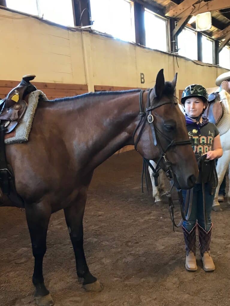 Our youngest daughter in the equestrian ring at horse camp with her horse.