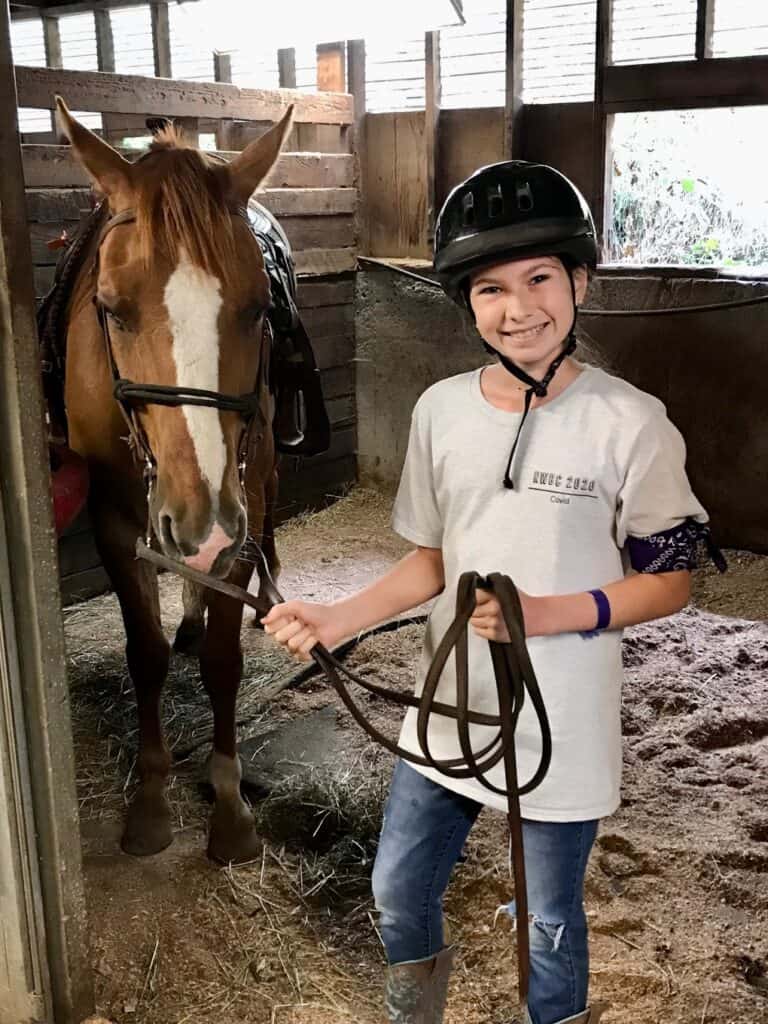 Our daughter leading a horse out of its stall.