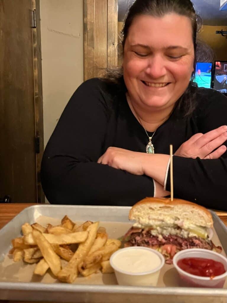 Jenn about to enjoy a burger and fries at The Gallon House.