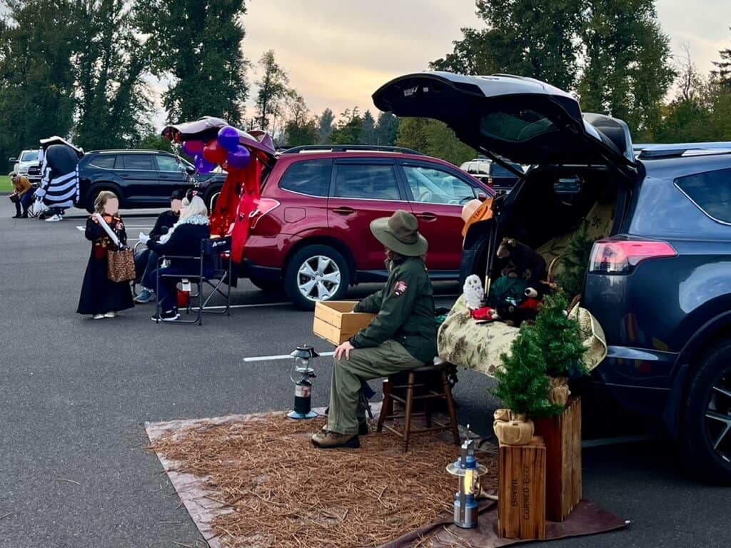 Cars parked in a parking lot for Trunk or Treat.