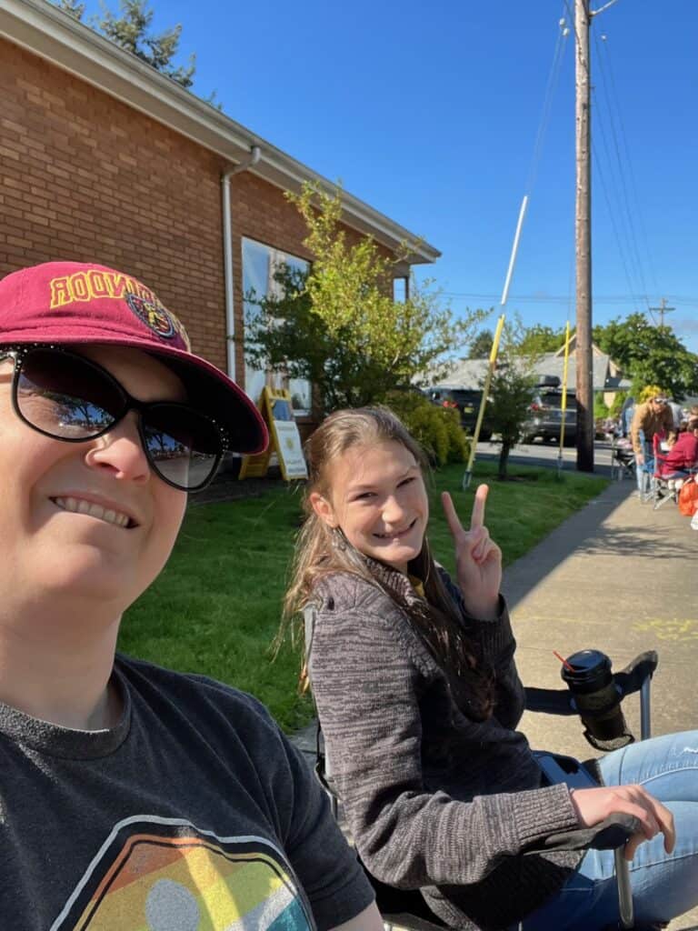 My daughter and I in camp chairs on the sidewalk in downtown Silverton, getting ready to watch the Silverton Kiwanis Pet Parade. There are so many kid-friendly activities in Silverton Oregon!