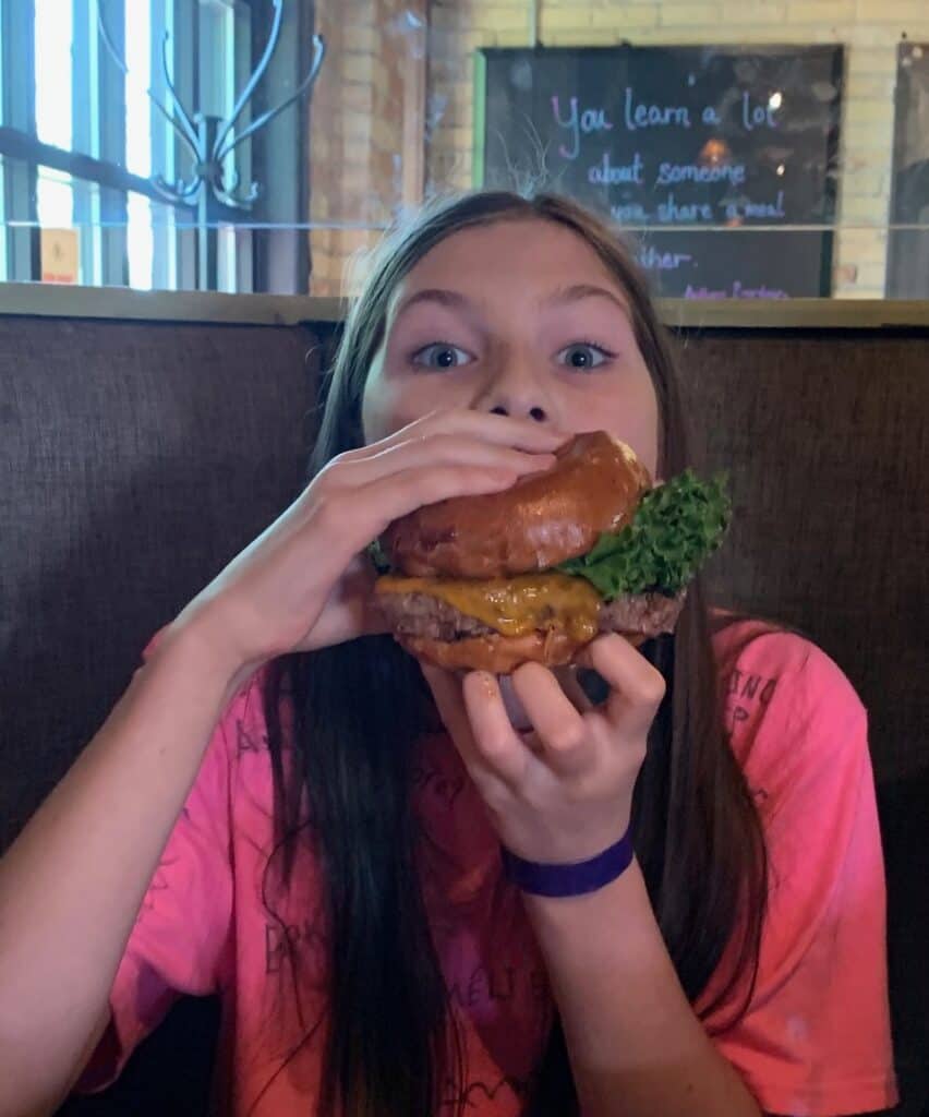 My daughter enthusiastically attempts to eat a Smashburger at Montana Ale Works. Montana Ale Works is one of the best restaurants in Montana.
