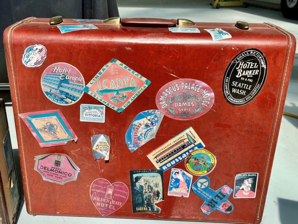 Antique red suitcase with travel stickers from various destinations. What to pack in a carry on for a teenager.