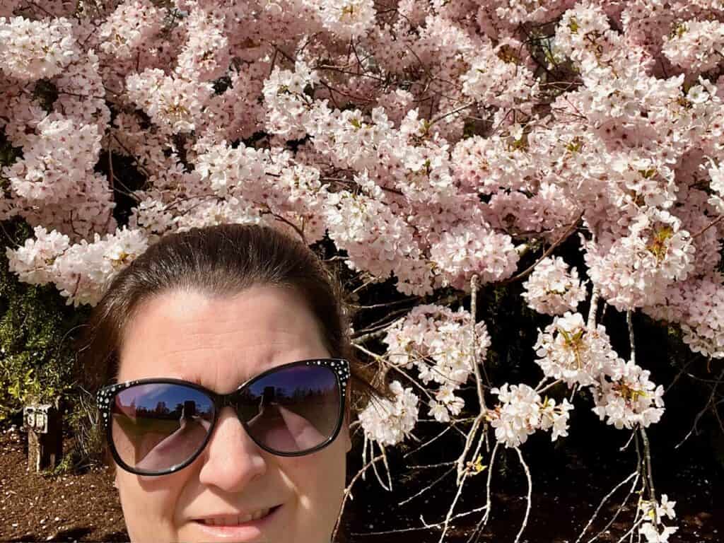 Jenn in front of cherry blossoms.