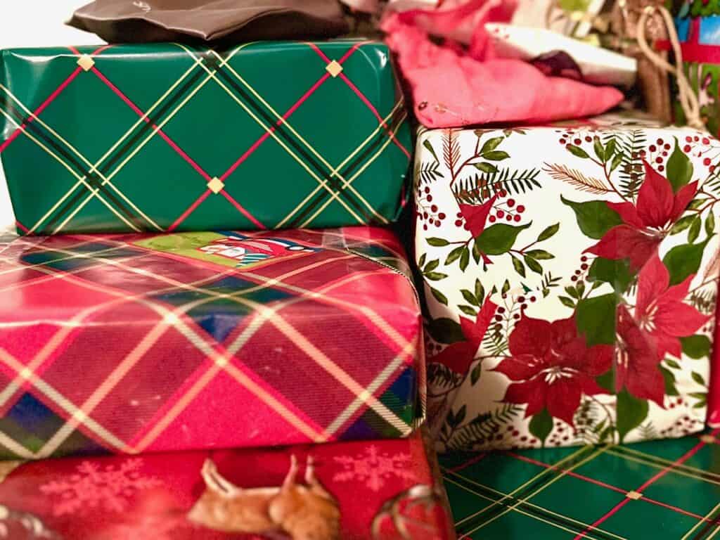Stack of wrapped gifts with Christmas wrapping paper.