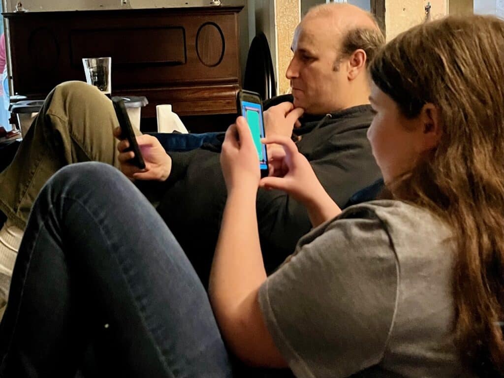 Brian and one of our daughters scrolling phones on our couch.