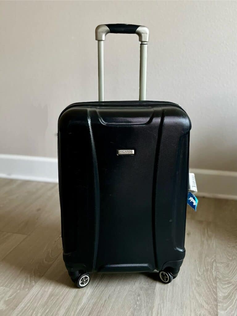 Black hard sided rolling suitcase.