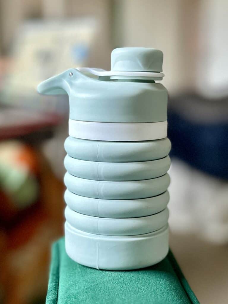 Light blue collapsible water bottle, collapsed.