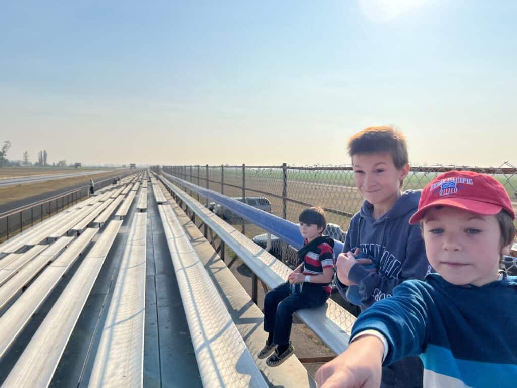 Our boys watching a race from the bleachers at the Woodburn Dragstrip. The Dragstrip is one of our favorite things to do with kids in Woodburn Oregon.