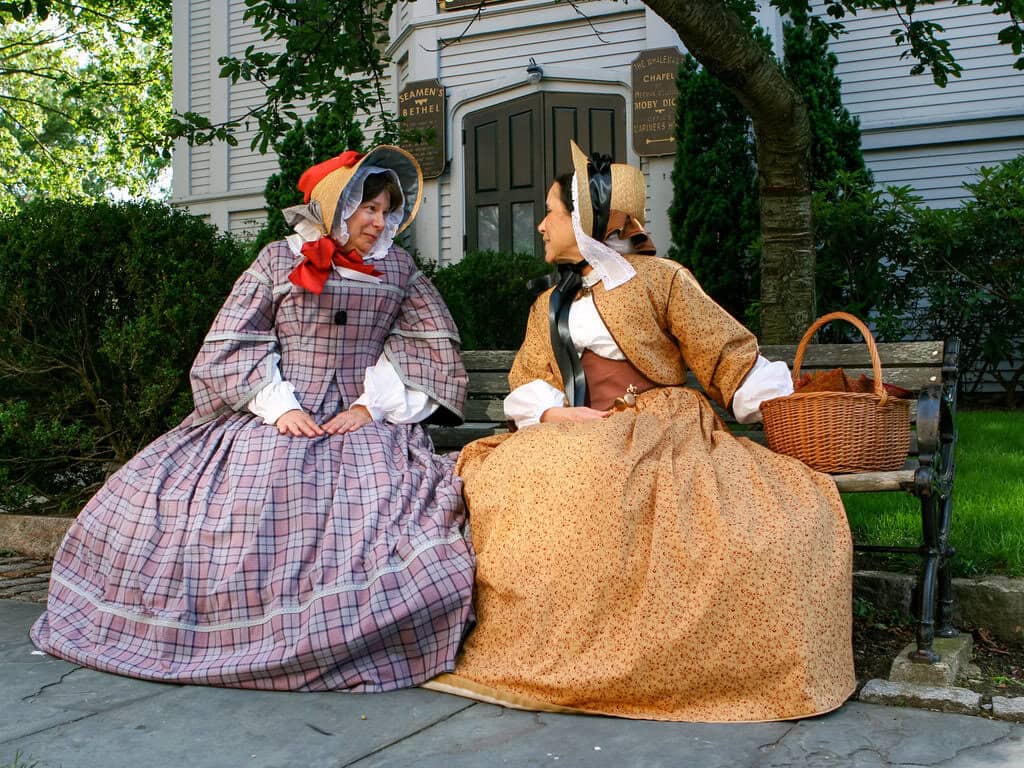 To women reenactors discuss the latest gossip at New Bedford Whaling National Historical Park.