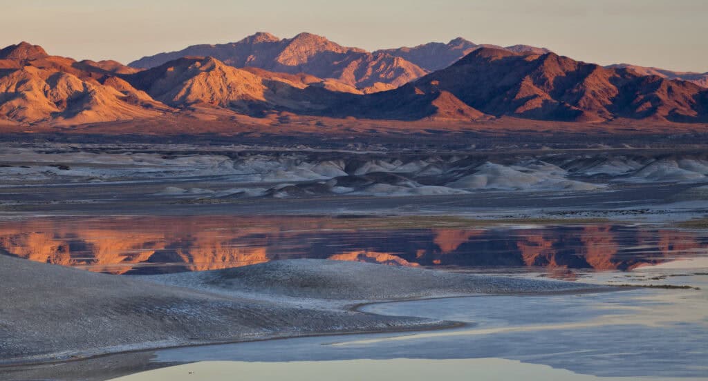 A desert lake reflects a desolate landscape along the Old Spanish National Historic Trail.