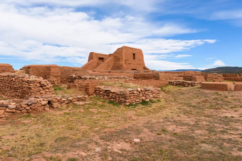 Indigenous ruins rise above the mountains of New Mexico at Pecos National Historical Park.