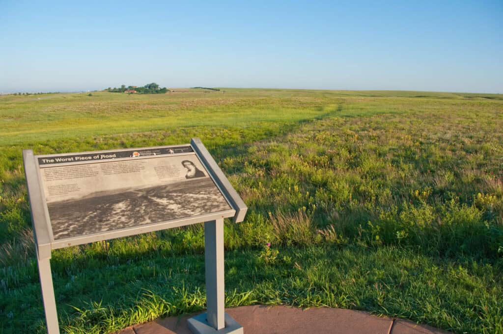 An interpretive plaque stands at attention as ruts run toward the horizon along Santa Fe National Historic Trail, Oklahoma.