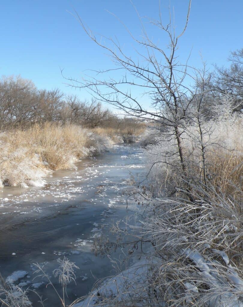 Snow and Ice fringe a river at Washita Battlefield National Historic Site.