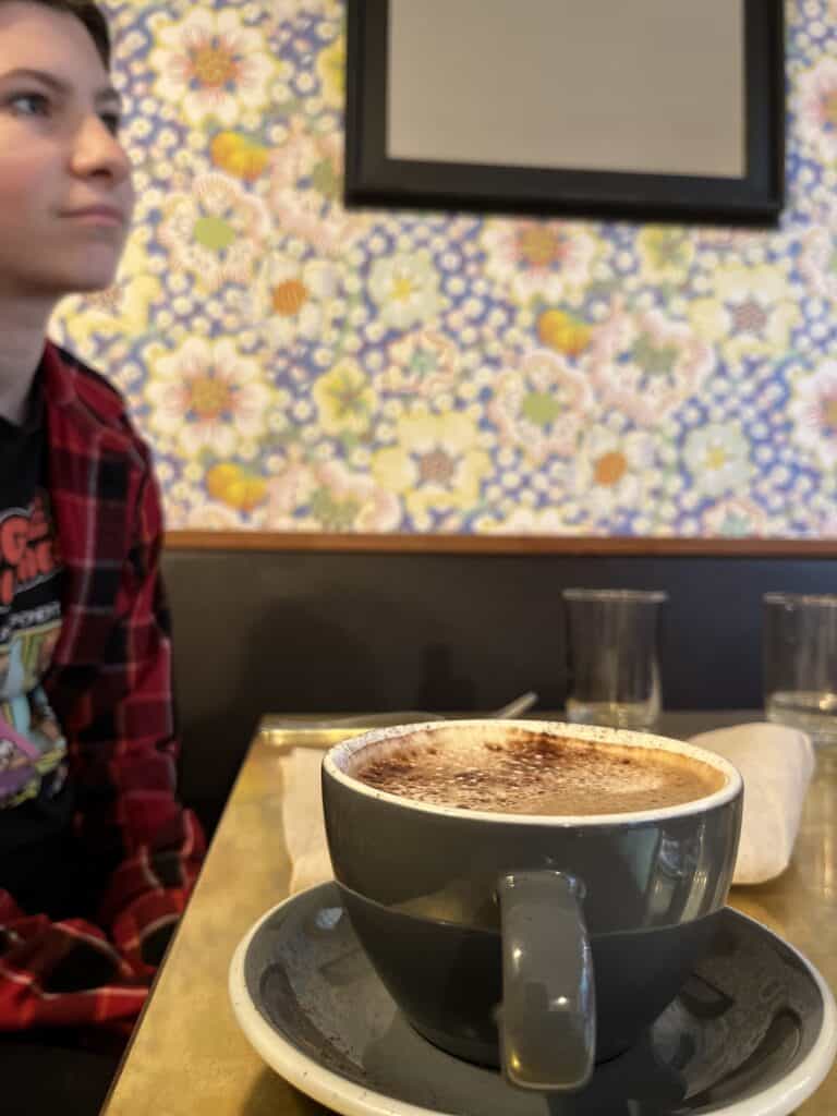 mug at table inside Broder Ost, our daughter is in the background