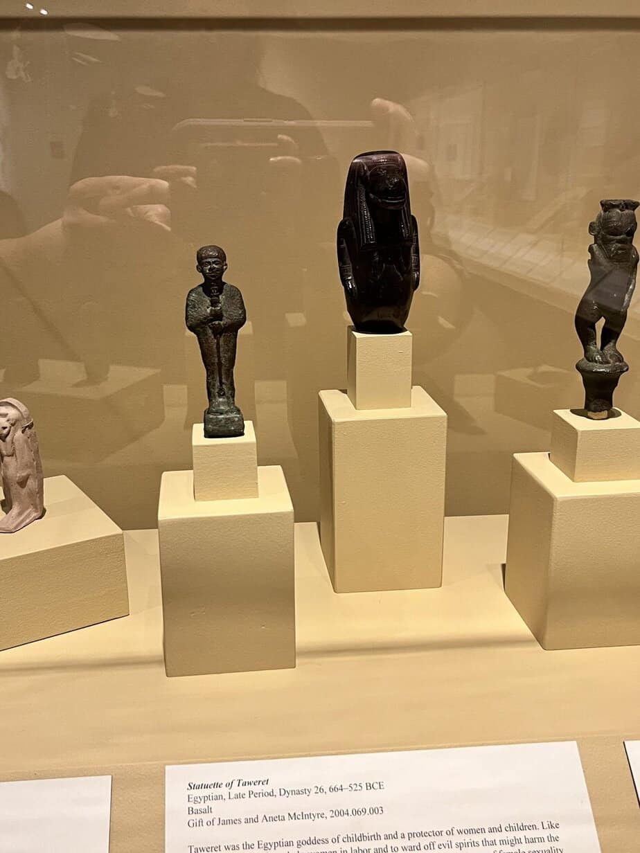 Ancient Egyptian statues on display in a glass case at the Hallie Ford Museum in Salem, Oregon