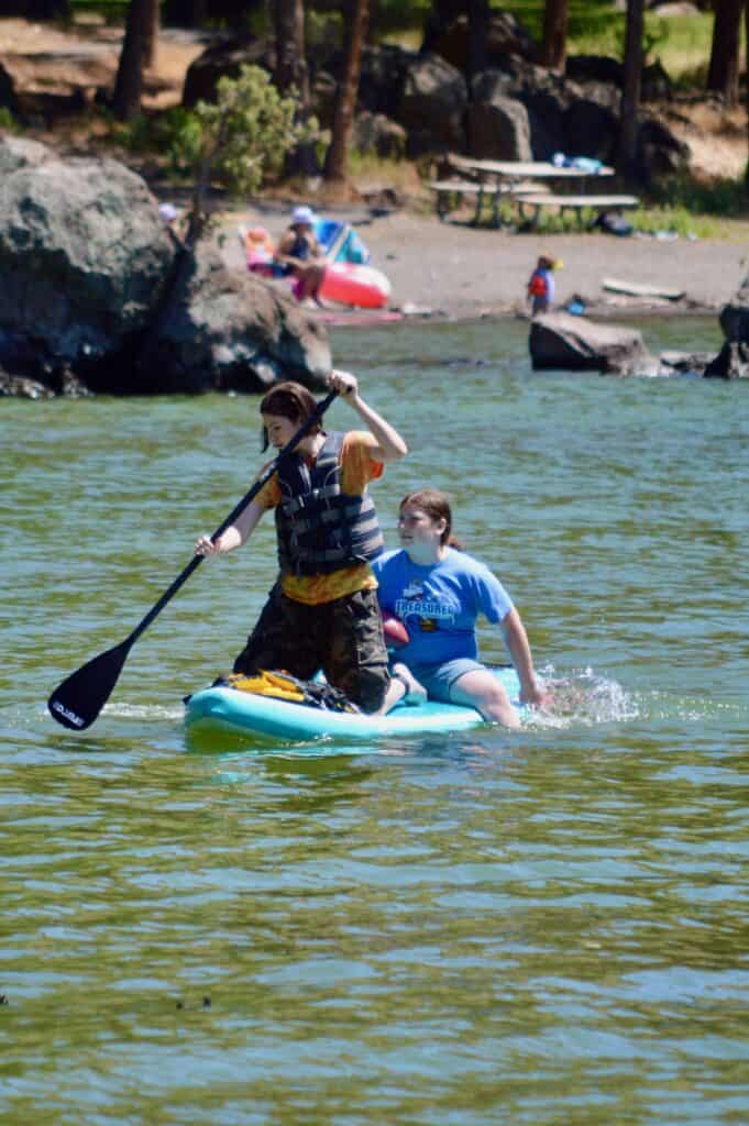 Our teen daughters paddleboarding on a lake