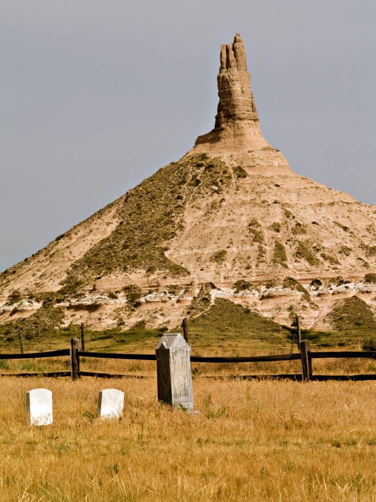Chimney Rock towers over a pioneer cemetery at Chimney Rock National Historic Site.