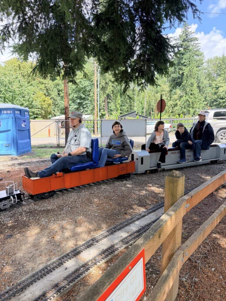Our three boys and Brian ride behind the conductor behind a miniature scale diesel engine.