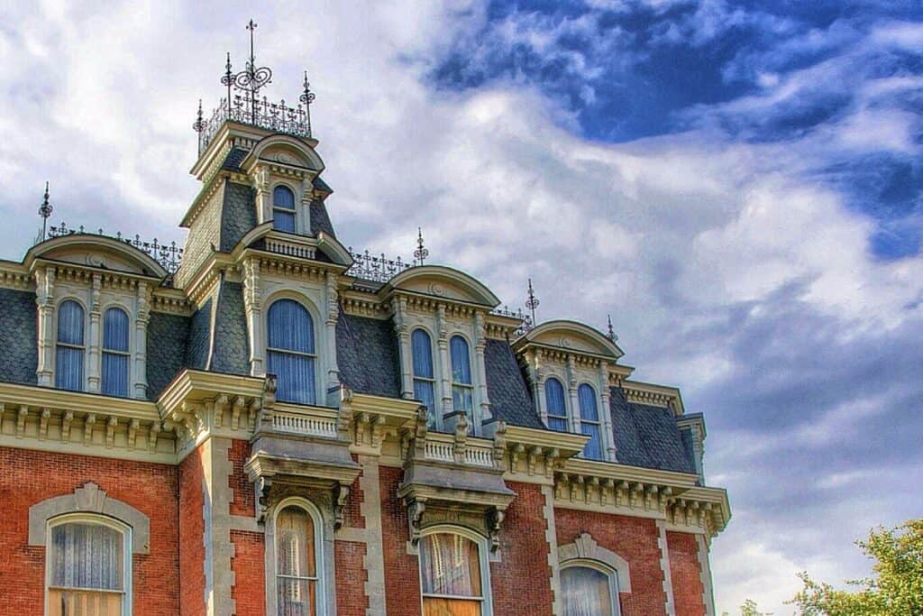 The upper stories of a red, white, and blue mansion vault to the skies along Captain John Smith Chesapeake National Historic Trail, New York.