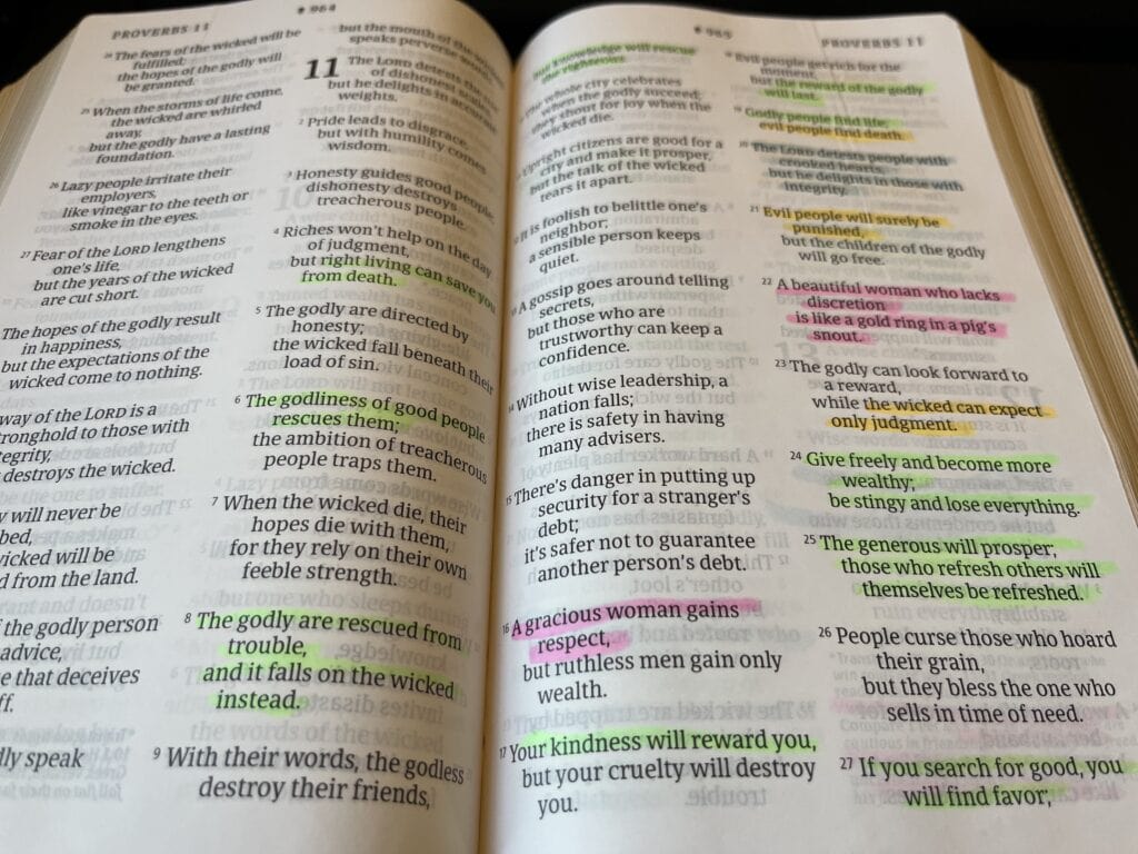 Open Bible showing Proverbs 11 with several verses highlighted
