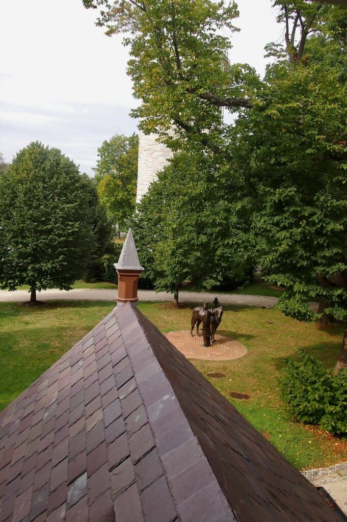 A view from a window of the Lincoln Summer Cottage looks down upon a bronze sculpture of Lincoln and his horse.