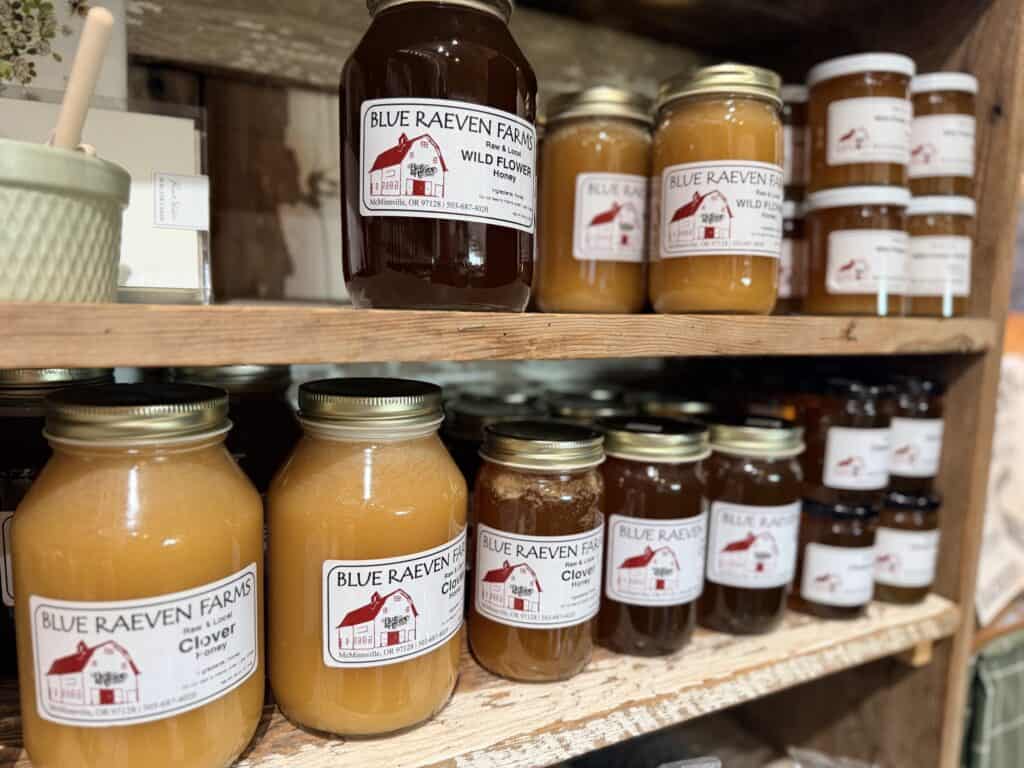 Rows of Blue Raeven honey jars on shelves.
