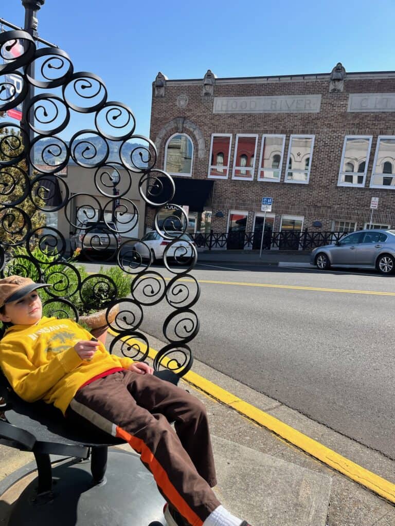 Our son chills out on a beautiful wrought iron bench in Hood River.