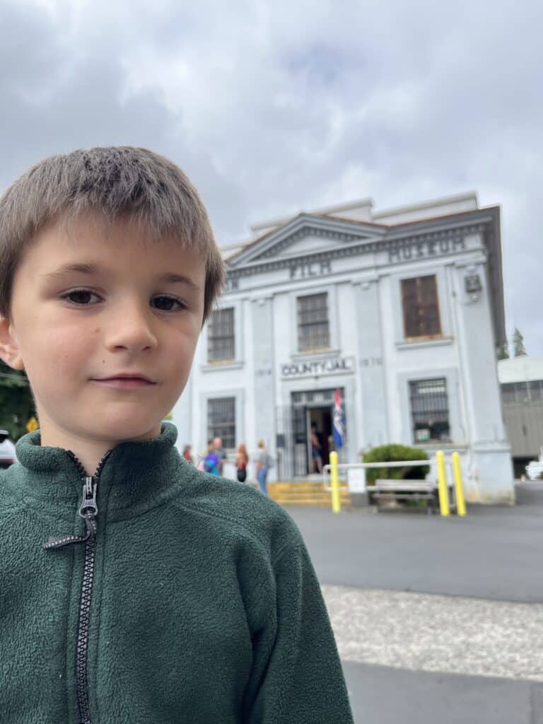 Our young son stands in front of the historic jail building that is now the home of the Oregon Film Museum.