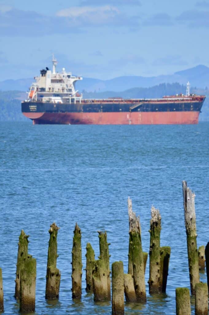 Typical scene from an Astoria pier - a shipping boat heading out to sea via the Columbia River.