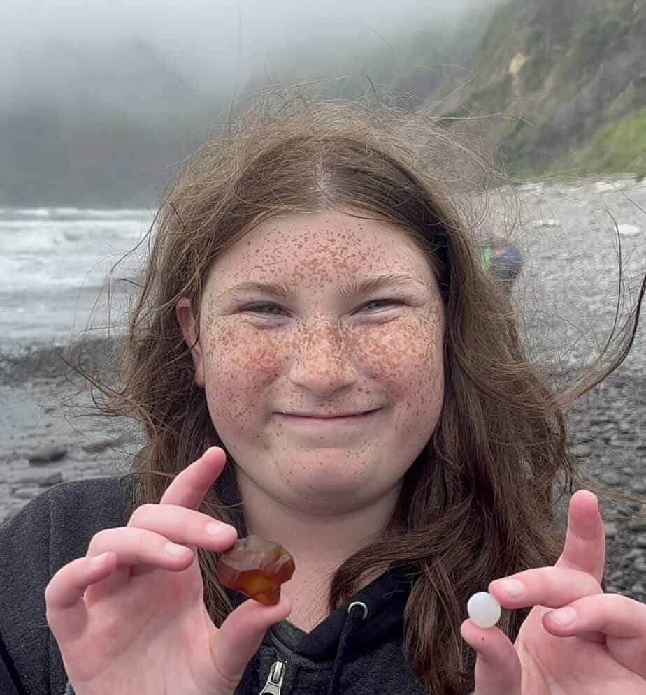 My daughter smiles while holding agates that she found at Short Beach in Tillamook, Oregon.