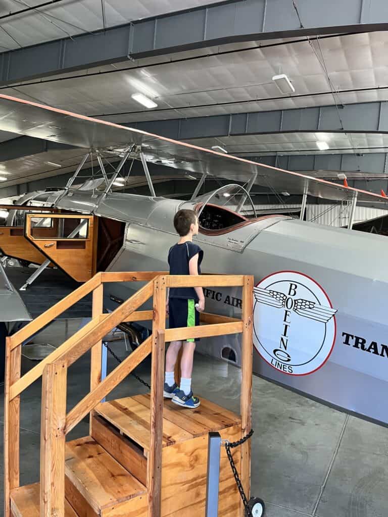 Our son looks inside the cockpit of an antique Boeing airplane at the Western Antique Airplane and Automobile Museum.