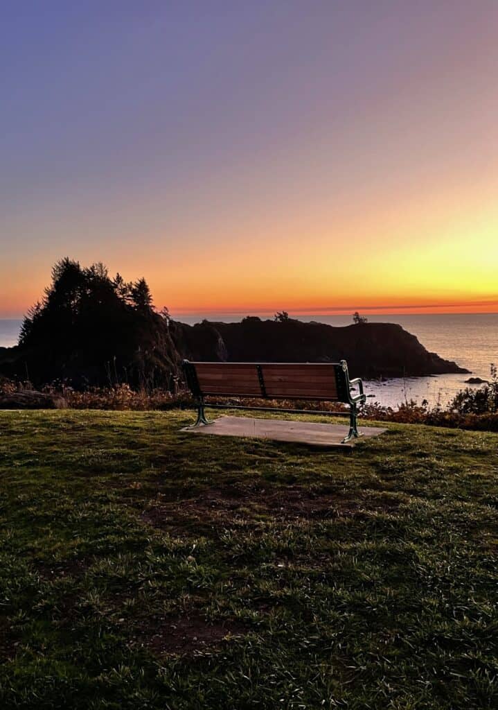 A bench sits before a beautiful sunset at Brookings, Oregon.