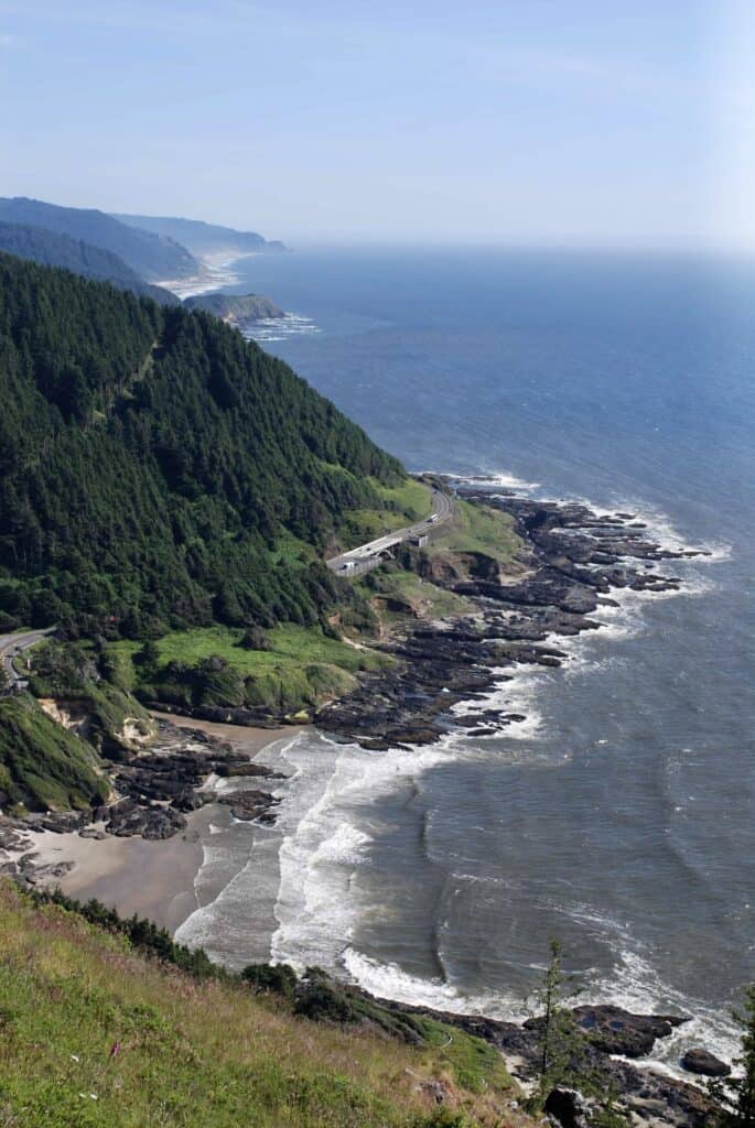 The forested slopes of Cape Perpetua tower over the Pacific Ocean.
