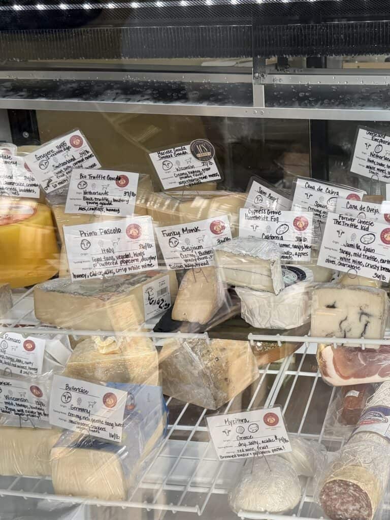 Cheese on display in refrigerator case.