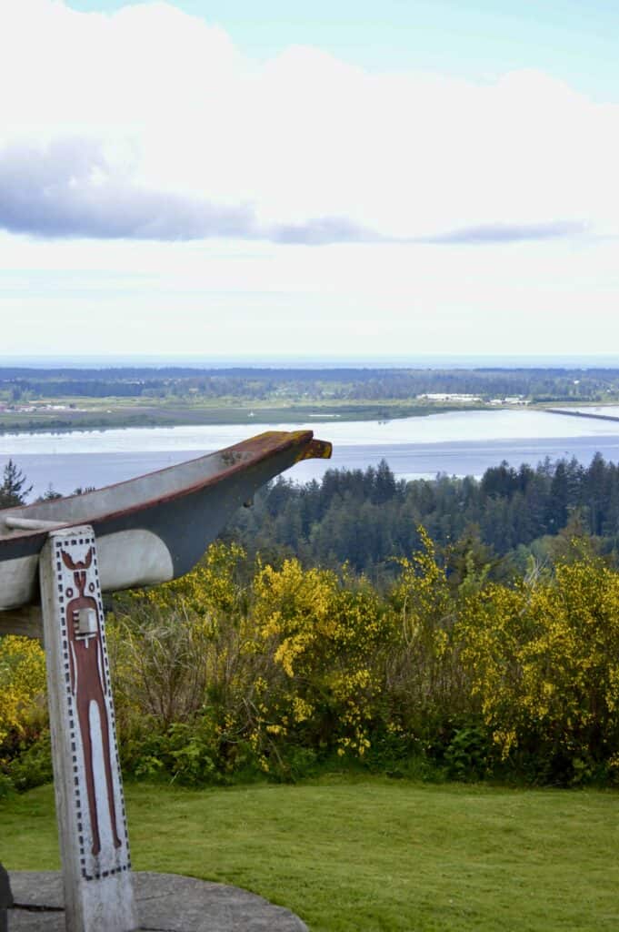 The Chief Comcomly Memorial stands in the foreground of a view of the Columbia estuary in Astoria.