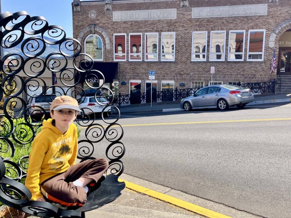 Boy in a metal sculptured chair in downtown Hood River.