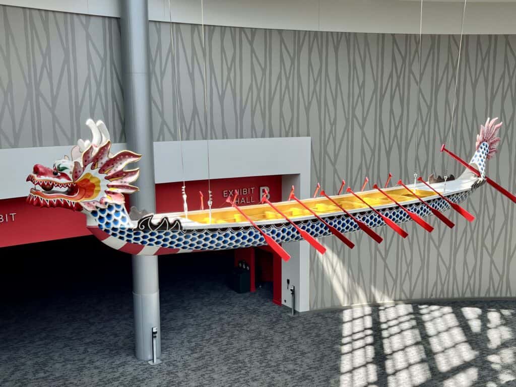 A red, yellow, black and white Chinese dragon boat hanging in the OCC.