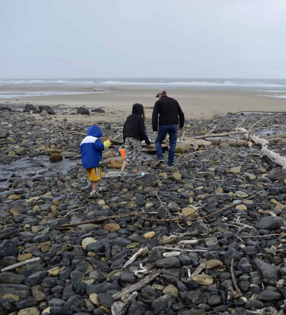 Brian and two of our children hunt for agates at Moolack Beach on a cloudy day.