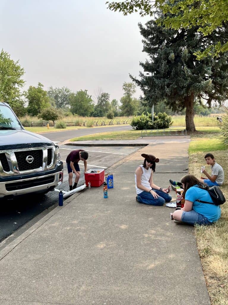Kids picnicking in the shade next to our parked van.