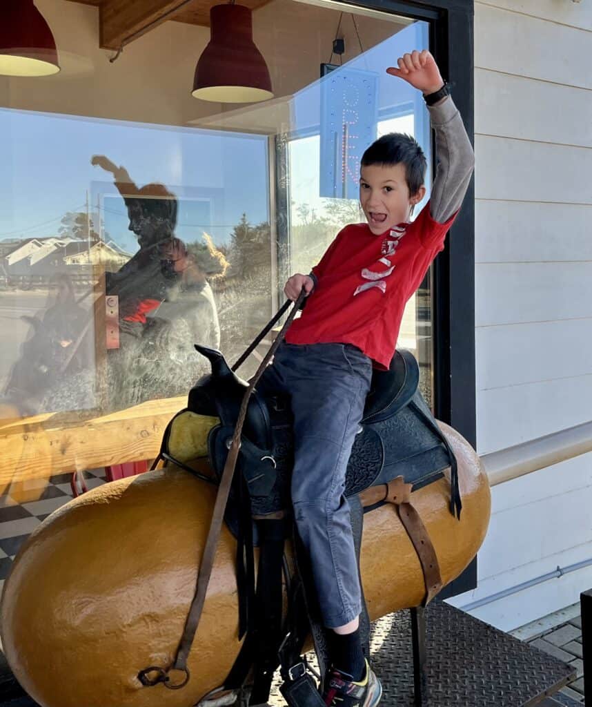 Our son stikes a rodeo pose as he rides the Corn Dog ride at Pronto Pup, Rockaway Beach.