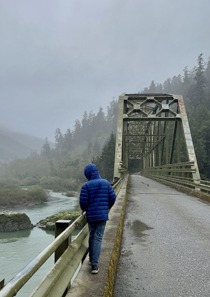 Our son looks over the Rogue River while walking over a tall bridge.